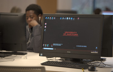 student working at a desktop computer in the library