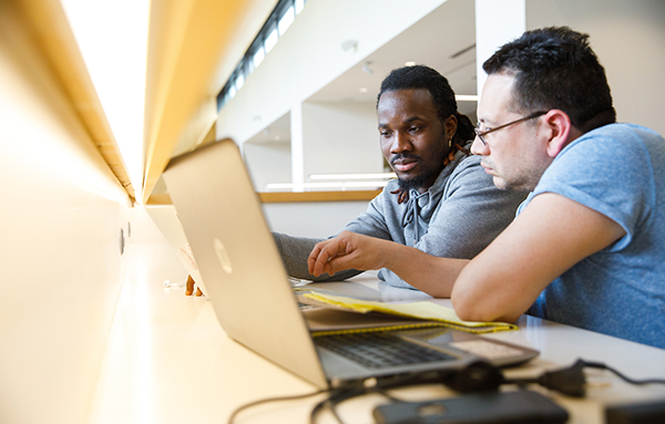 two male students working in library