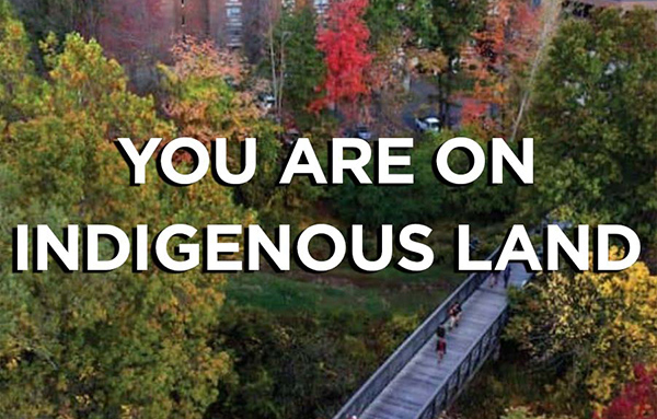Sky view of campus bridge with words "You are on Indigenous Land"