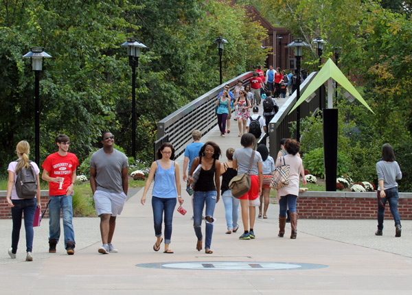 Students crossing bridge into Alumni Plaza