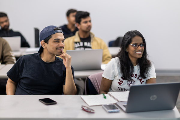 image is of students learning in a classroom.