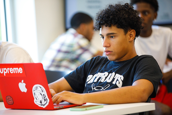 An African American male student working on a laptop
