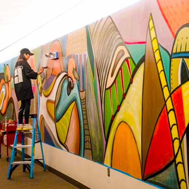 Lingshan Zheng paints a mural at the University of Hartford