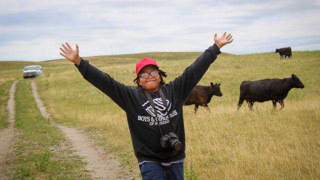 Student at Star Stories waving to camera