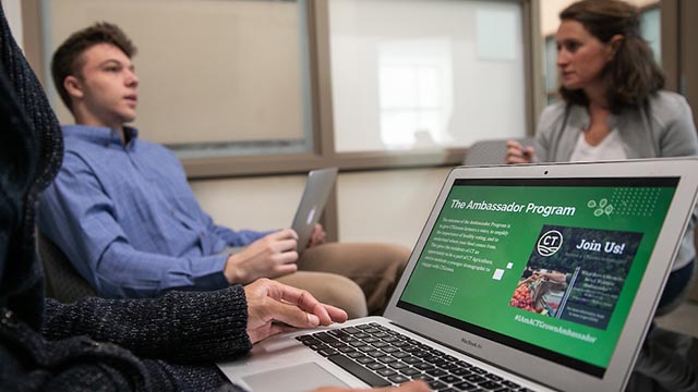 professor and student in class with presentation on computer