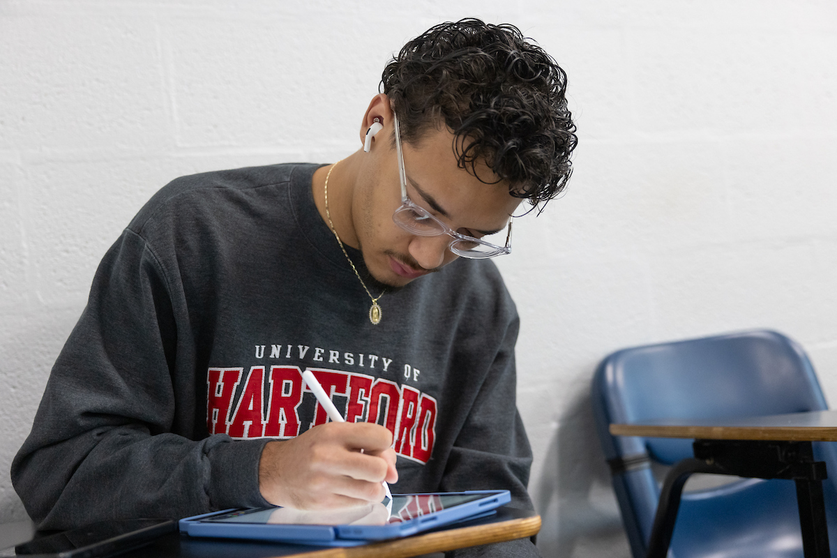 Uhart student studying and writing on ipad