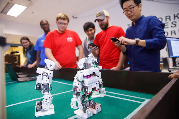 Students collaborating with hands-on robotics project.