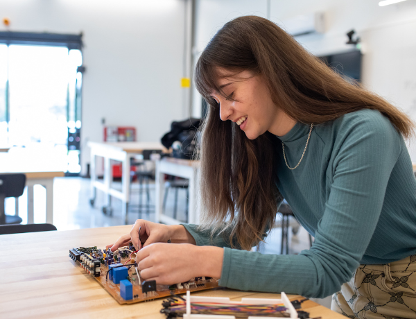 female electrical engineering student working on device