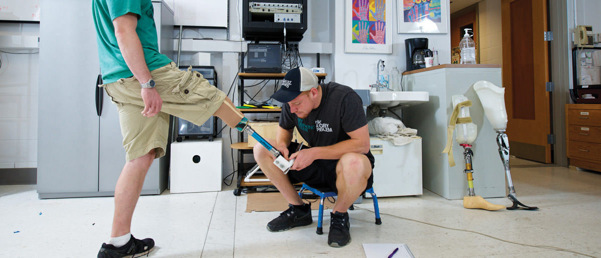 Student examining prosthetic leg