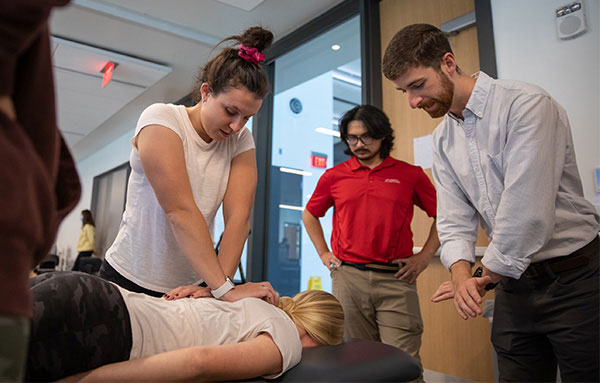 faculty member working with student in classroom