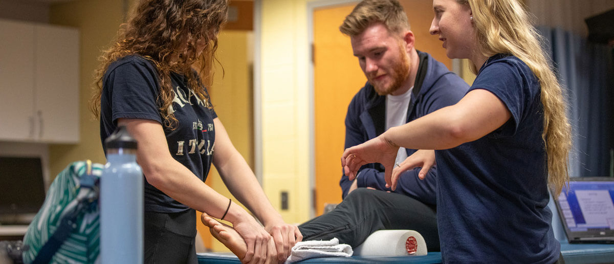 physical therapy student manipulating leg