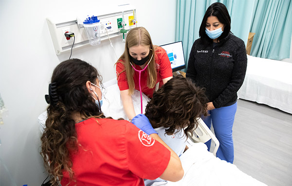 nursing students in simulation lab with manikin