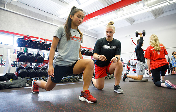 two female students exercising in gym