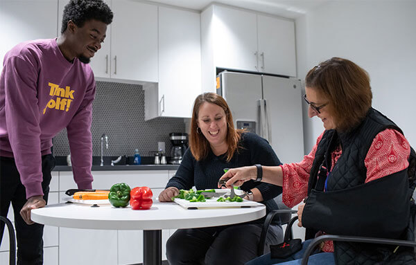 therapist helping client in kitchen