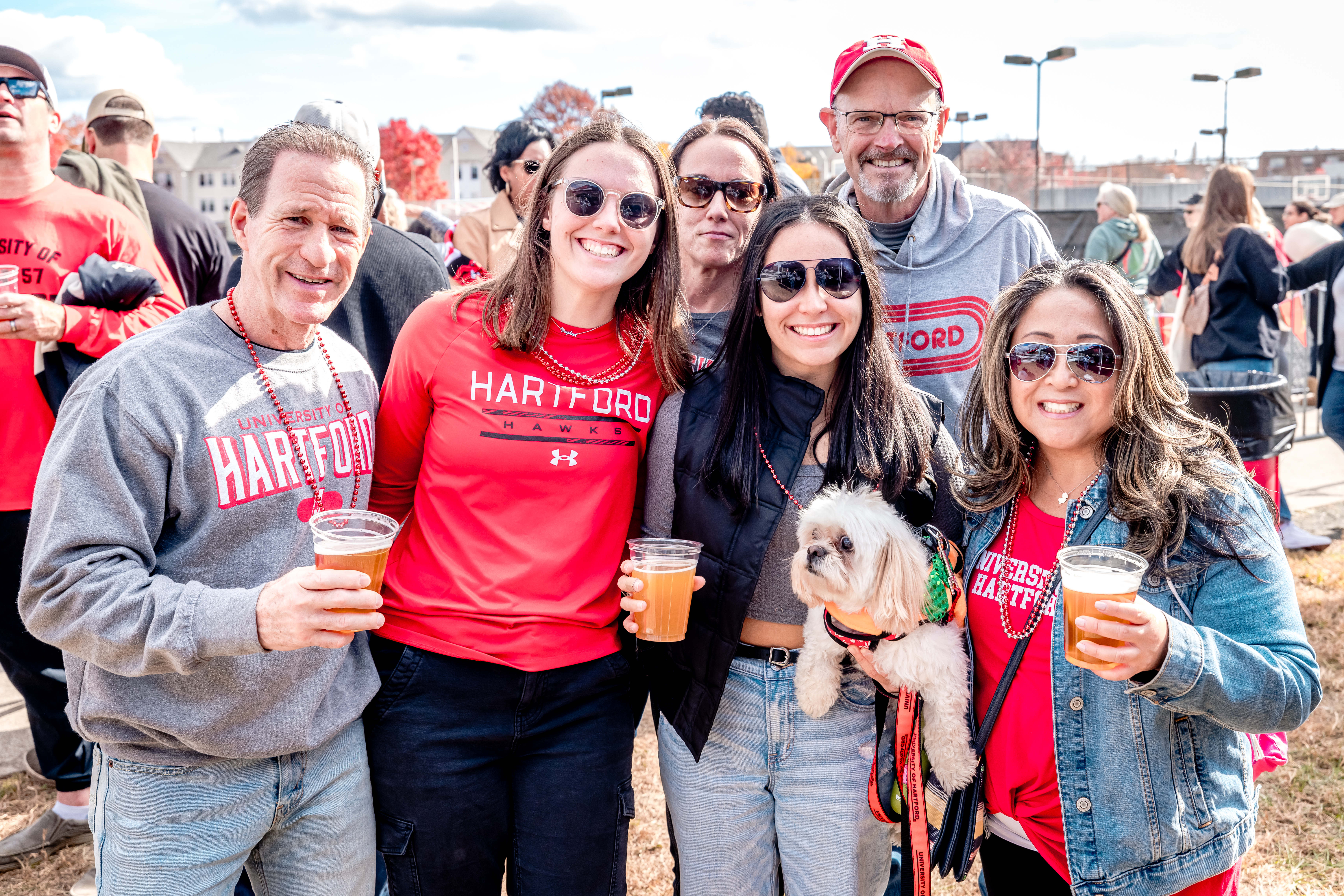 UHart Alumni posing for a group photo with drinks in hand.