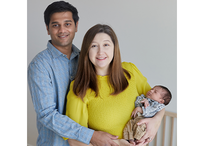 Katelyn Whitburn Reddy and her husband holding their newborn baby.