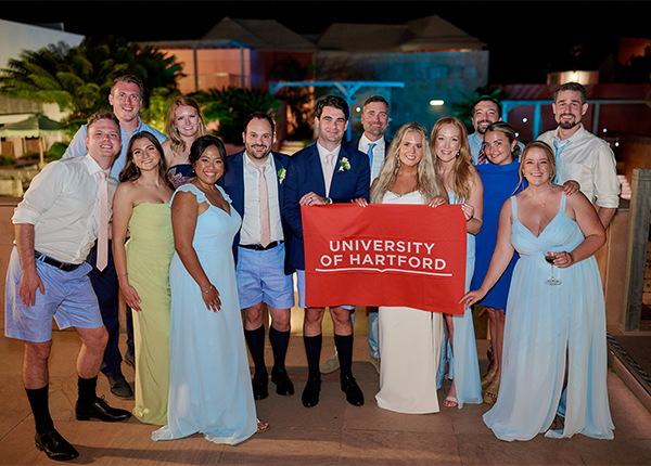 group photo at a wedding with UHart banner
