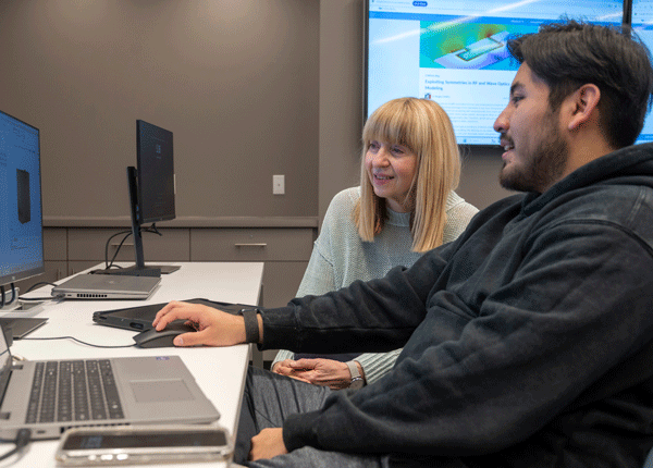 student and teacher working on a computer