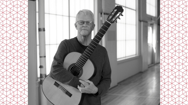 A headshot of Dave McLellan holding a guitar