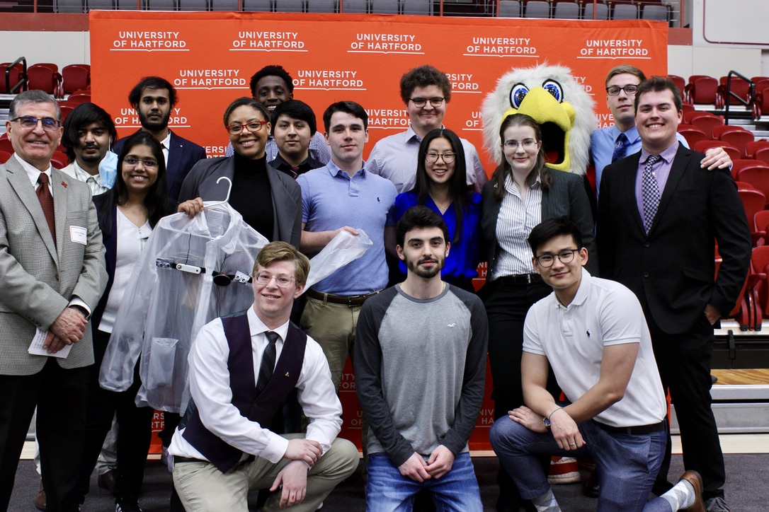 Group of students posing together smiling for award.