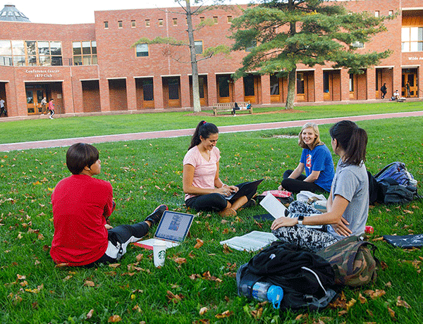 students sitting on the lawn