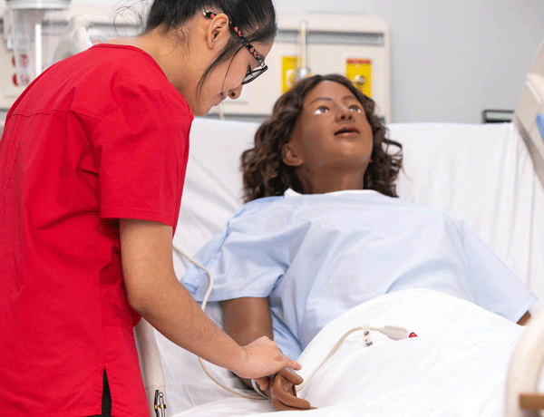 Student learning how to take a pulse on a mannequin