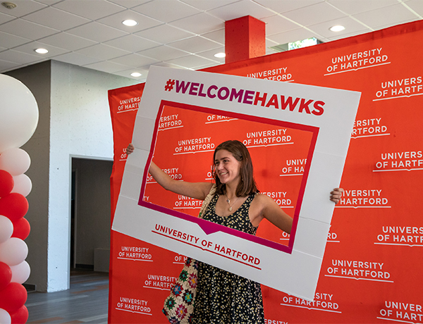 student holding welcome back sign