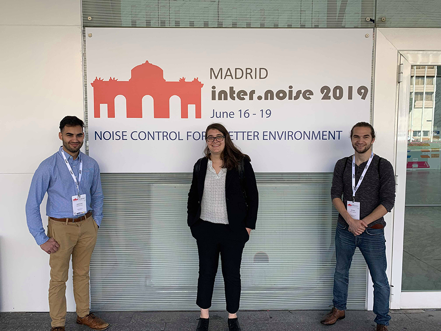 Students in front of sign at conference