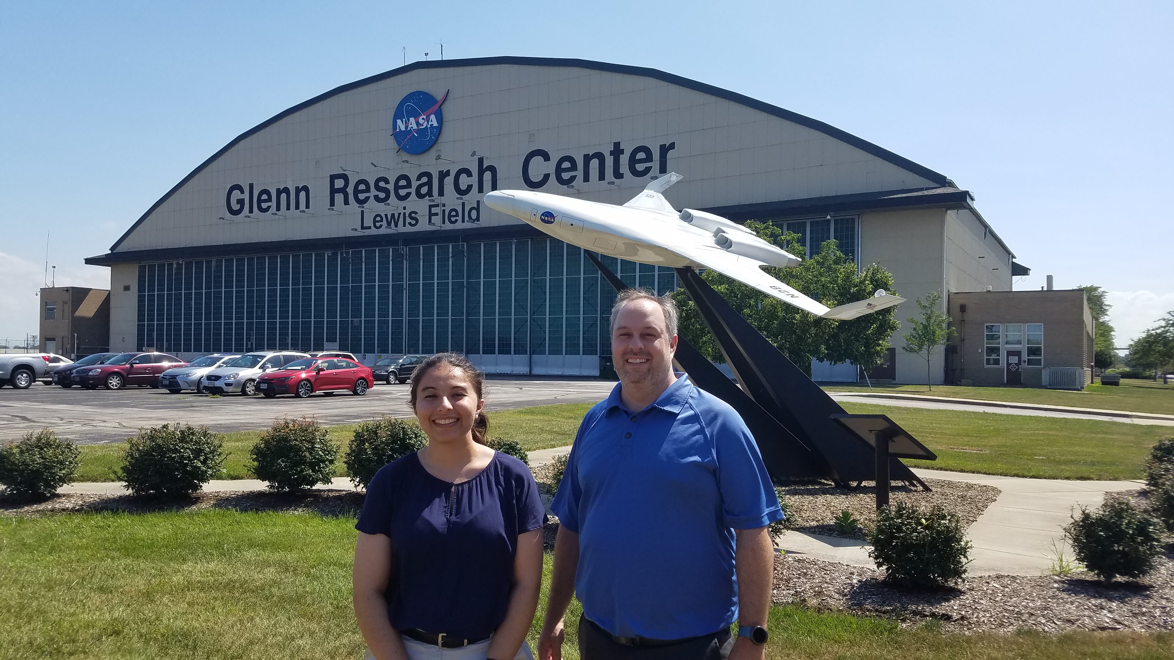 student and faculty member in front of nasa glenn center buidling