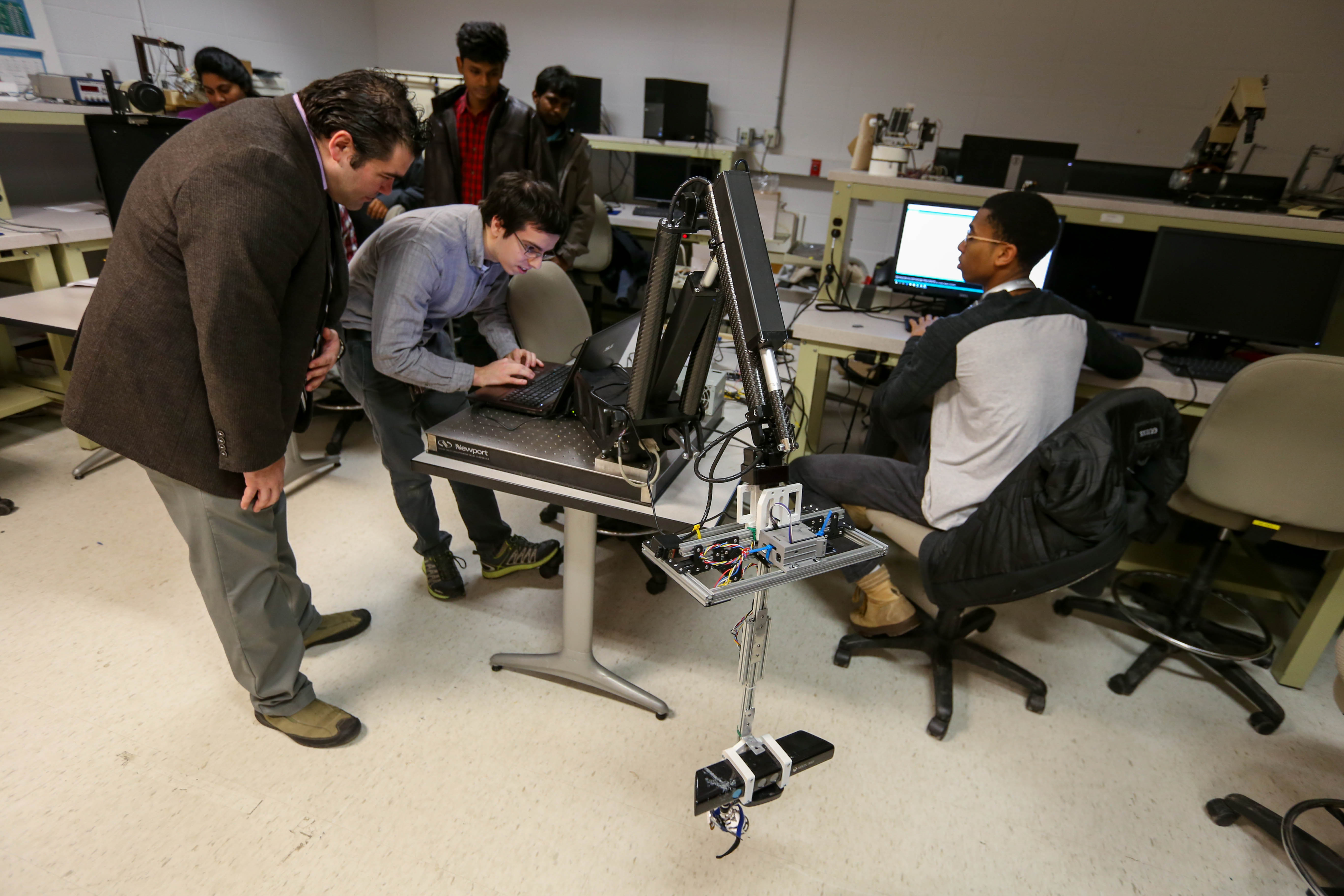 students and professor in robotics lab