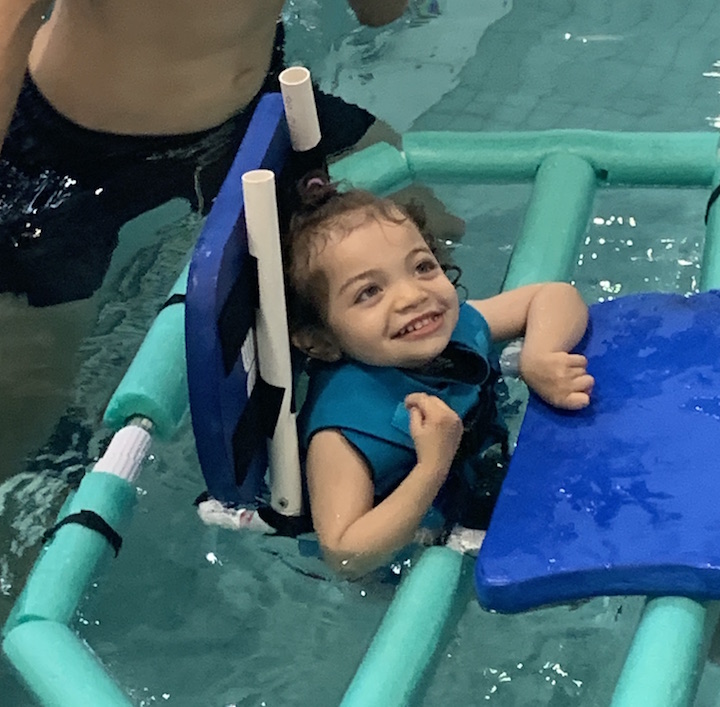 Child in water strider with head rest