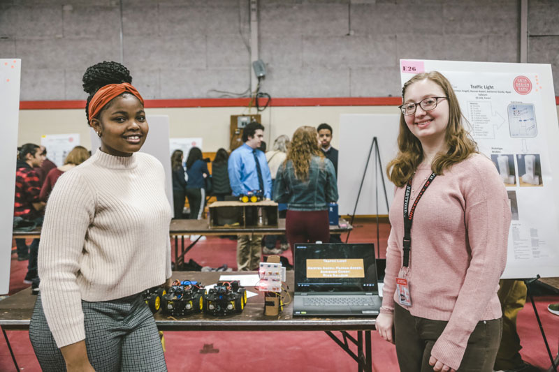 two female students in front of project