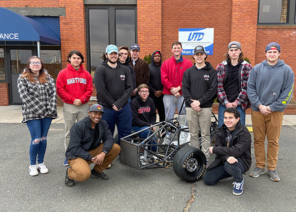 people standing infront of racecar