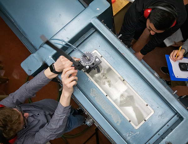 students working on wind tunnel machine