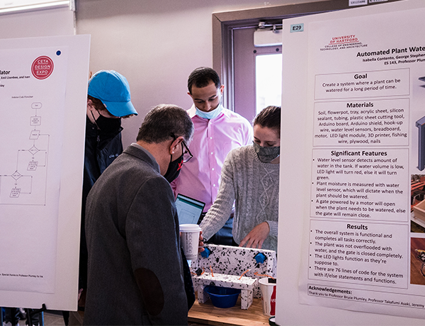 people gathered around table looking at project