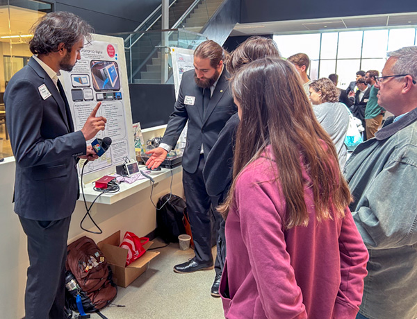 Students and faculty discussing an exhibit at the CETA Spring Expo