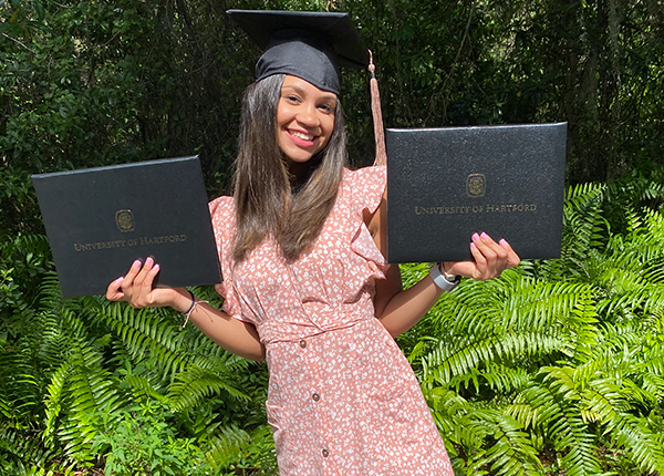 female student holding two diplomas