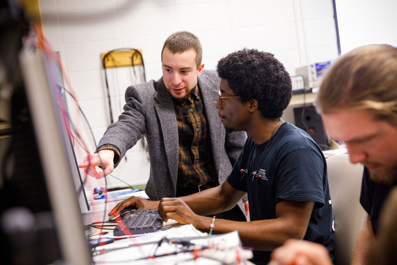 two individuals working on a computer