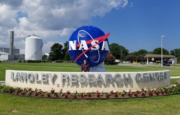 male in front of NASA center logo