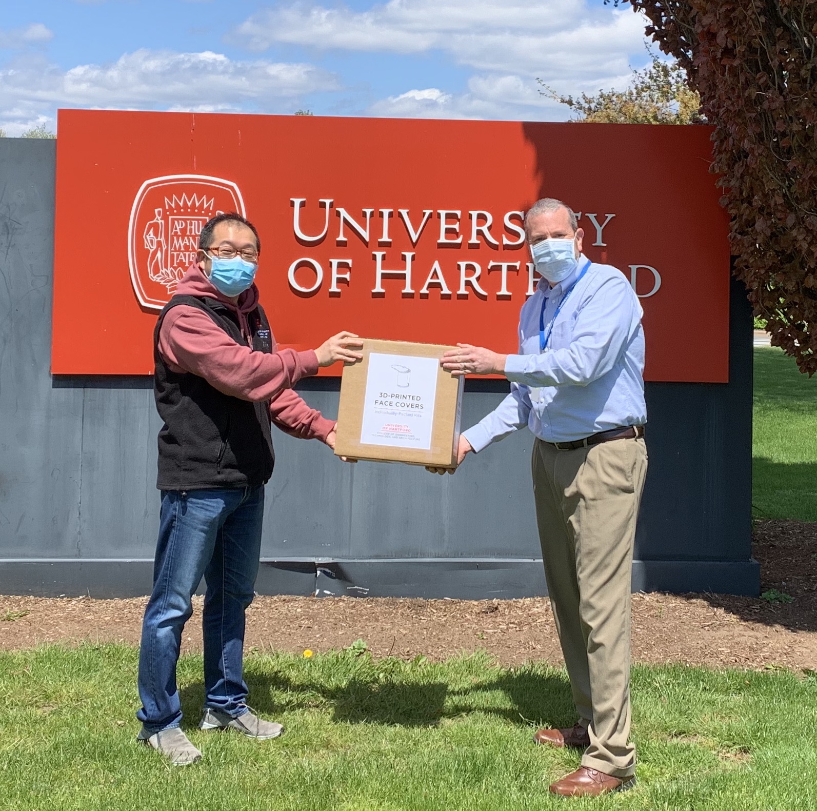 photo of Prof Asaki handing box to Adam Raider '94 of Masonicare